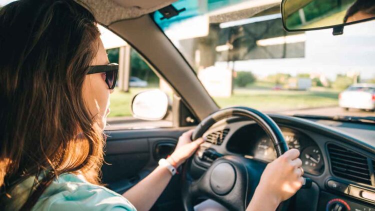 Mujer conduciendo un coche al atardecer, ejemplo de vehículo de gasolina, diésel o eléctrico y su vida útil sin averías