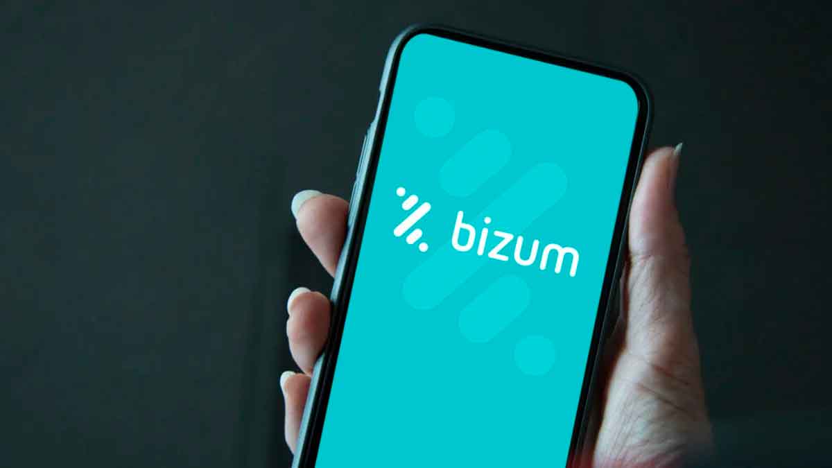 Mano sujetando móvil con logo de Bizum, aplicación controlada por Hacienda desde 2026 para autónomos y empresas