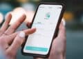 Mano de autónoma usando la app Bizum en el móvil para enviar dinero, operaciones que controlará Hacienda desde enero de 2026