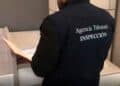 Inspector de la Agencia Tributaria revisando documentos durante inspección fiscal a autónomo