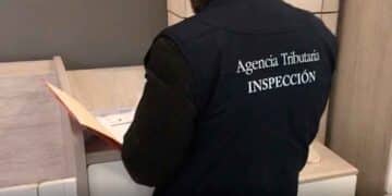 Inspector de la Agencia Tributaria revisando documentos durante inspección fiscal a autónomo