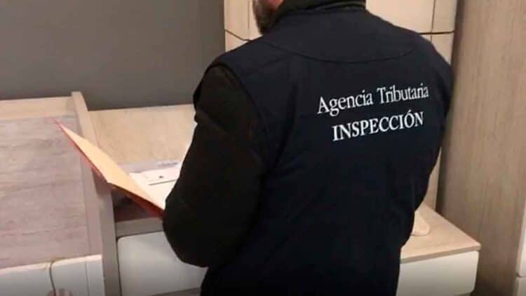 Inspector de la Agencia Tributaria revisando documentos durante inspección fiscal a autónomo