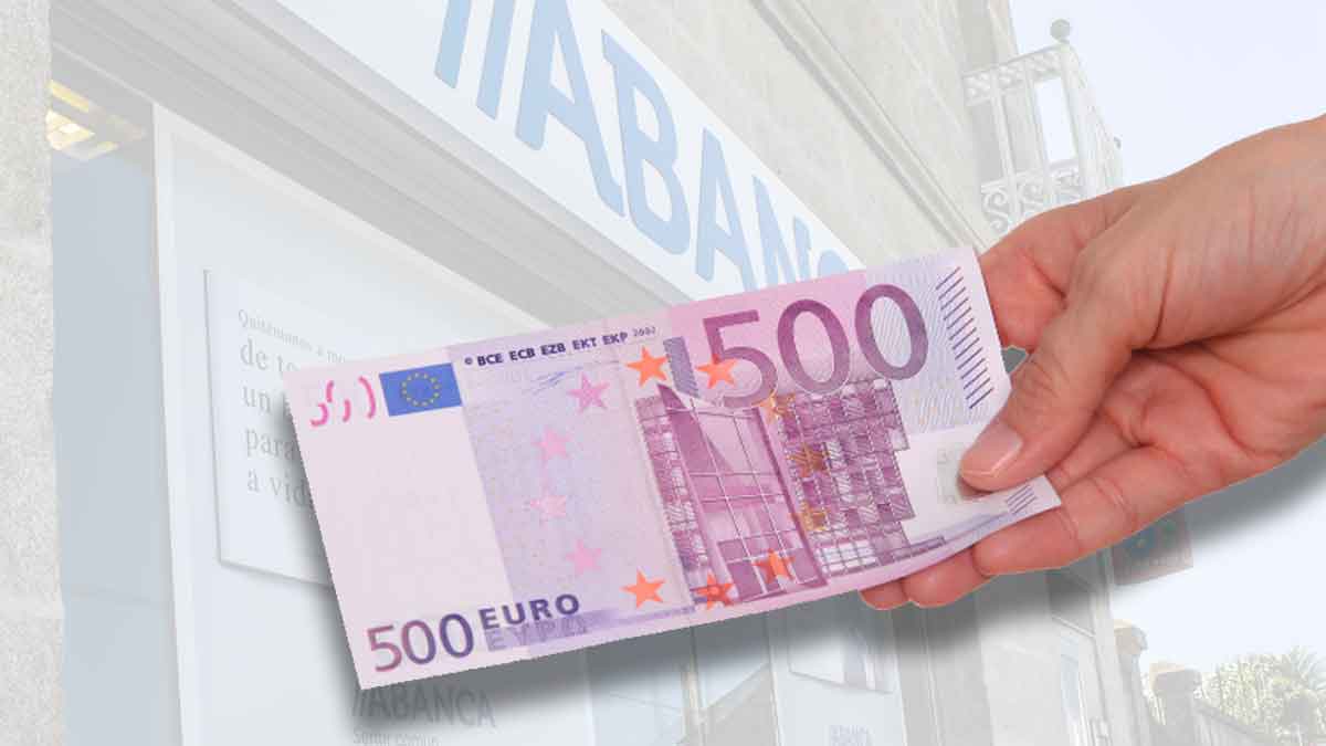 Mano sosteniendo un billete de 500 € frente a una sucursal bancaria, símbolo de las promociones de hasta 500 € por domiciliar la nómina en junio 2025