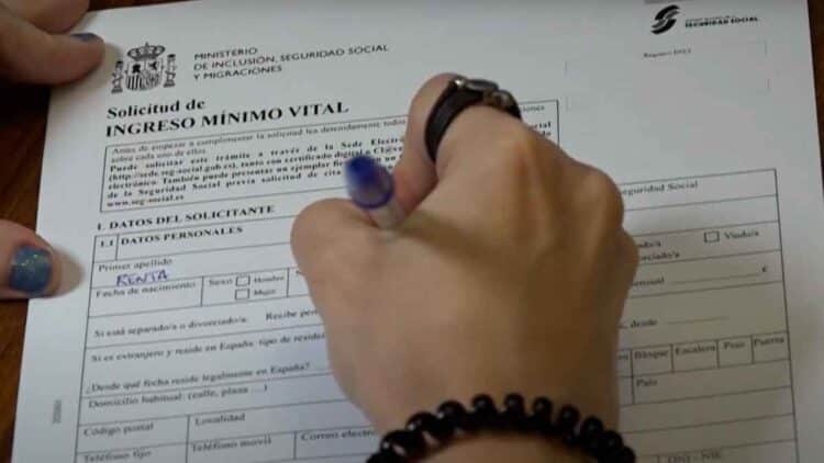 Persona rellenando la solicitud del Ingreso Mínimo Vital del INSS para obtener la cuantía máxima en junio 2025