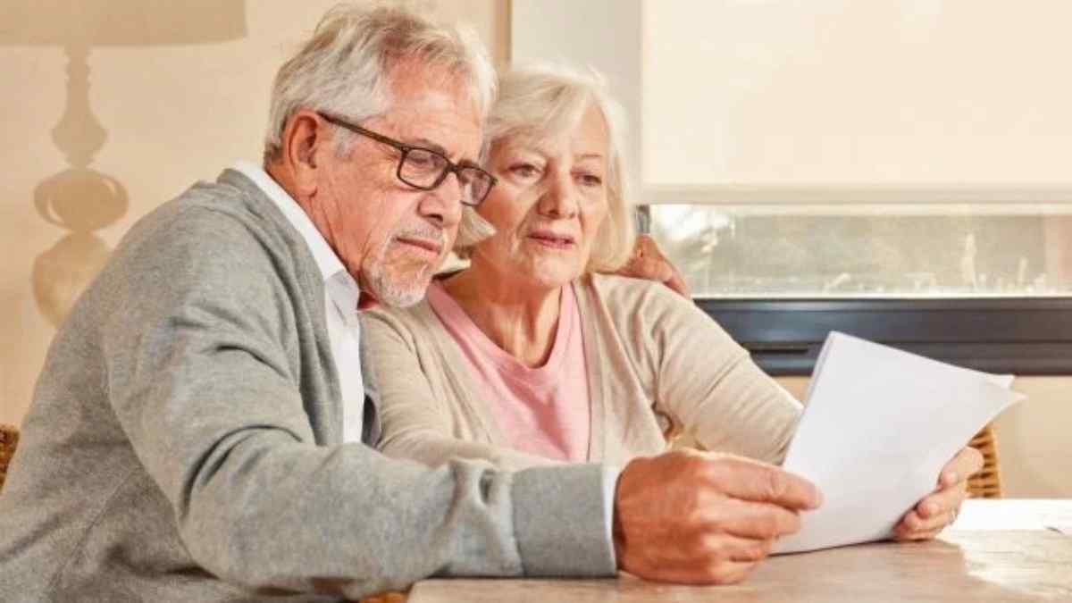 Pareja de jubilados revisando documentos para acceder a la pensión completa al 100 % en 2025.