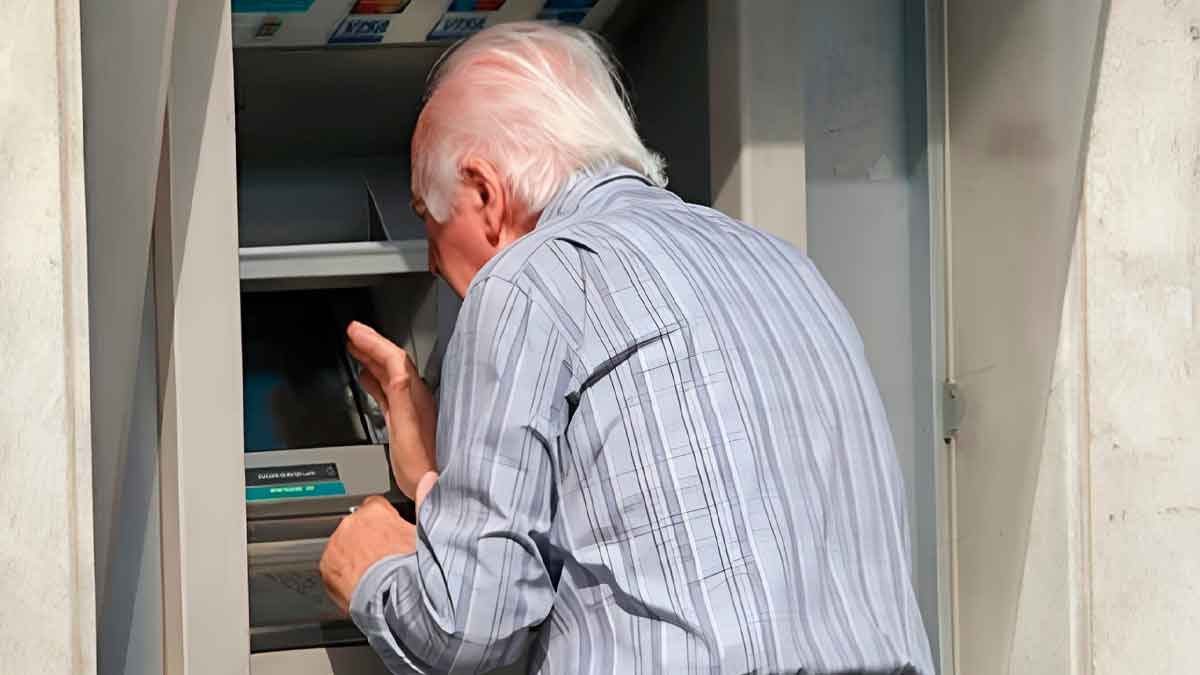 Pensionista retirando efectivo del cajero tras cobrar la paga extra de verano 2025 que duplica su pensión de junio