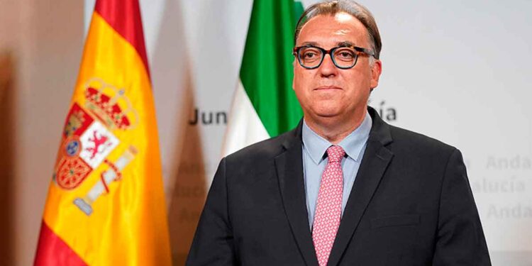 Representante de la Junta de Andalucía ante las banderas de España y Andalucía presenta las nuevas ayudas para andaluces en el extranjero