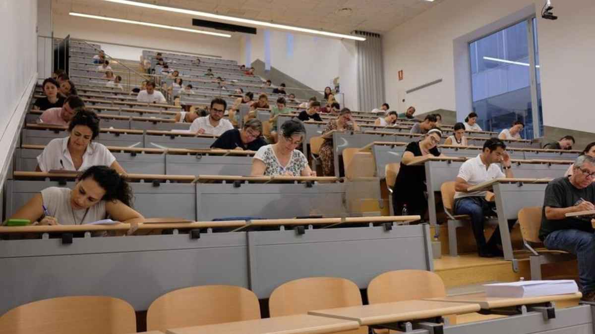 Aspirantes a oposiciones docentes en Andalucía durante el examen tras retrasos y preguntas erróneas.