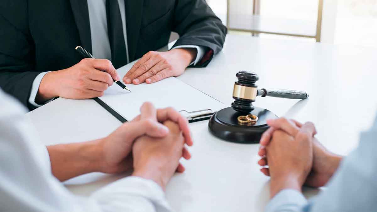 Abogado redacta acuerdo de pensión compensatoria indefinida o temporal tras divorcio, con martillo judicial y alianzas sobre la mesa