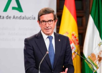 Jorge Paradela, consejero de Industria, presenta en rueda de prensa las ayudas del Plan MOVES III 2025, con banderas de España y Andalucía al fondo