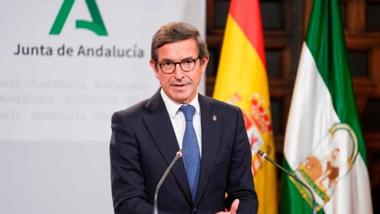 Jorge Paradela, consejero de Industria, presenta en rueda de prensa las ayudas del Plan MOVES III 2025, con banderas de España y Andalucía al fondo