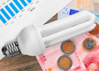 Bombilla de bajo consumo sobre euros y gráfico mensual, símbolo de ahorrar 10 % en la factura de la luz en verano