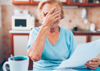 Mujer mayor preocupada revisa documentos sobre el retraso de la jubilación a 66 años y 10 meses desde 2026