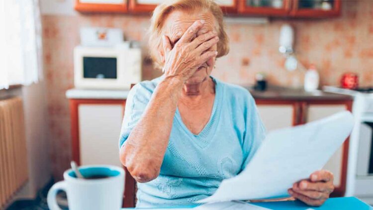 Mujer mayor preocupada revisa documentos sobre el retraso de la jubilación a 66 años y 10 meses desde 2026