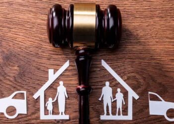Mazo judicial sobre mesa y figuras familiares y de bienes divididos, símbolo del divorcio económico y reparto de bienes en España