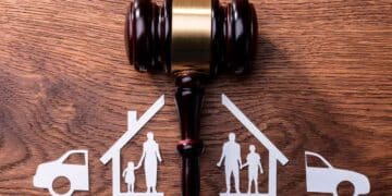 Mazo judicial sobre mesa y figuras familiares y de bienes divididos, símbolo del divorcio económico y reparto de bienes en España