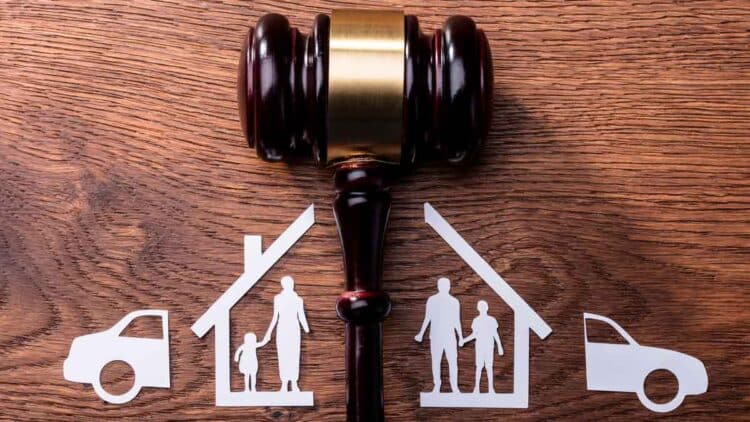 Mazo judicial sobre mesa y figuras familiares y de bienes divididos, símbolo del divorcio económico y reparto de bienes en España