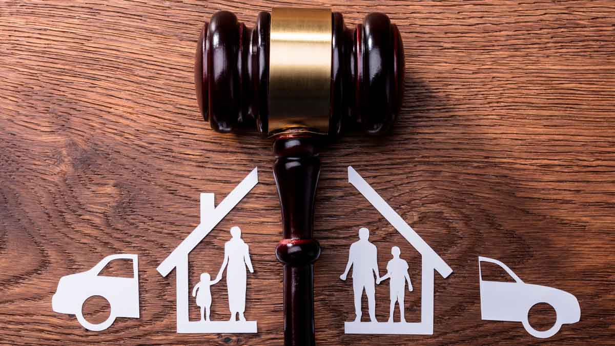Mazo judicial sobre mesa y figuras familiares y de bienes divididos, símbolo del divorcio económico y reparto de bienes en España