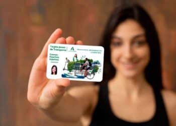 Joven andaluza mostrando la Tarjeta Joven de Transporte con la que ahorra hasta un 100 % en autobuses y metro