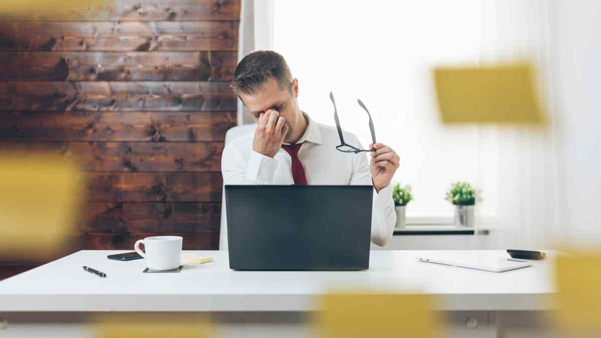 Trabajar frente al ordenador y fatiga ocular: empleado se frota los ojos y sujeta gafas; sentencia obliga a empresa a pagarlas.