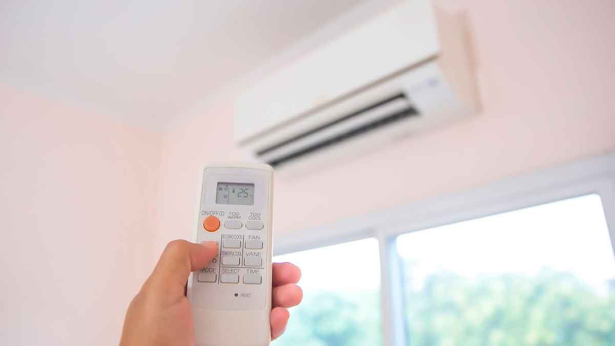 Persona usando mando de aire acondicionado para ahorrar energía en verano