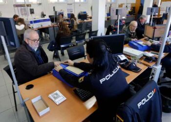 Funcionaria de la Policía Nacional toma huellas digitales a un ciudadano durante el trámite de renovación del pasaporte