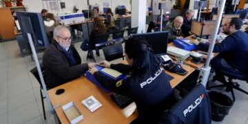 Funcionaria de la Policía Nacional toma huellas digitales a un ciudadano durante el trámite de renovación del pasaporte