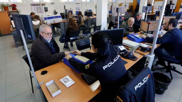 Funcionaria de la Policía Nacional toma huellas digitales a un ciudadano durante el trámite de renovación del pasaporte