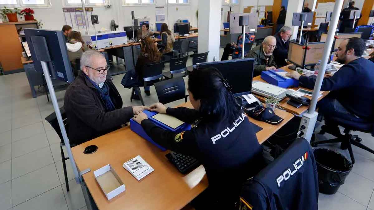 Funcionaria de la Policía Nacional toma huellas digitales a un ciudadano durante el trámite de renovación del pasaporte