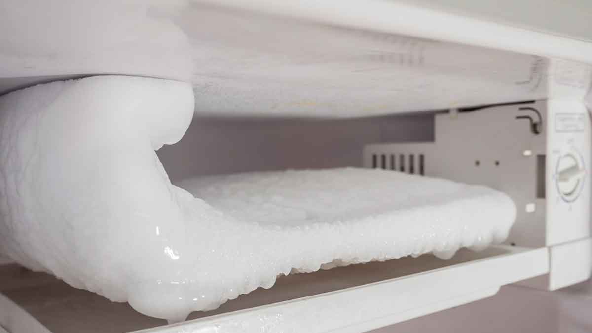 Gruesa capa de hielo en la balda del congelador antes de aplicar el truco de papel de aluminio y vapor para descongelar