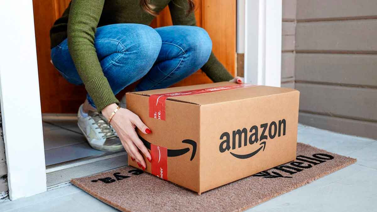 Mujer recogiendo un paquete entregado por Amazon en la puerta de su casa, siguiendo recomendaciones para evitar estafas