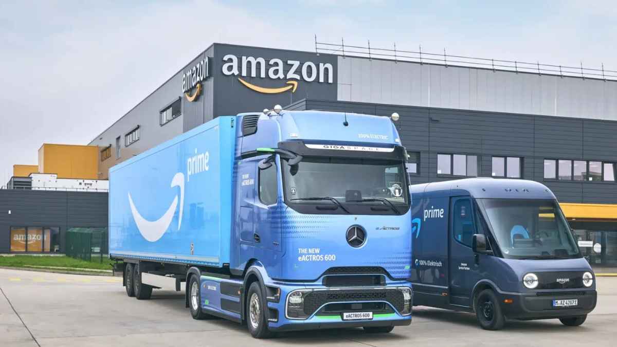 Camiones eléctricos de reparto de Amazon Prime preparados frente a un centro logístico.