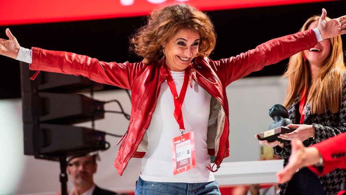 La ministra de Hacienda con chaqueta roja celebrando la confirmación de la subida salarial para trabajadores públicos en julio