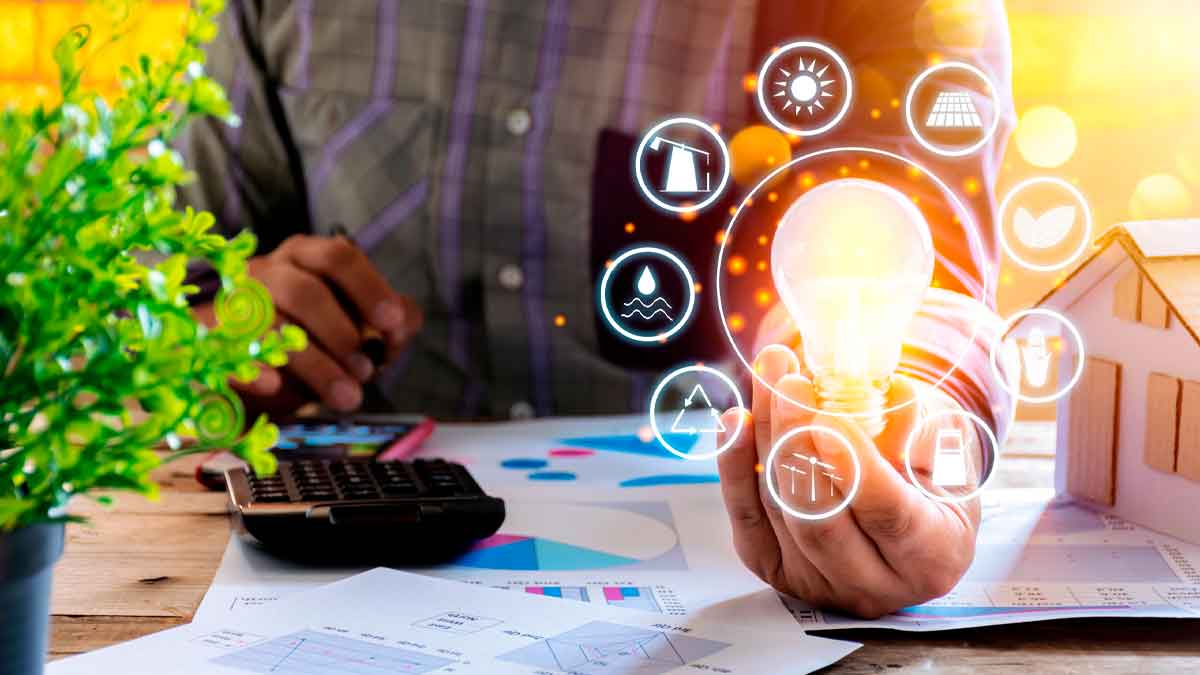 Persona calcula factura de luz con bombilla y gráficos sobre descuentos del bono social eléctrico en julio 2025