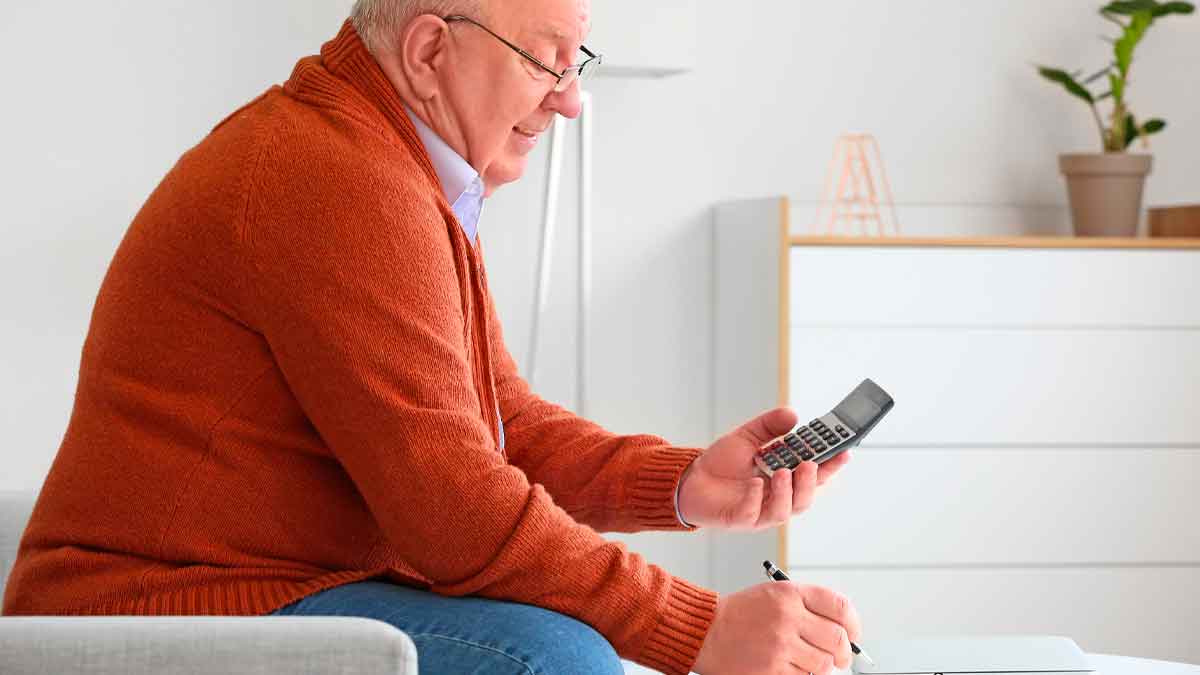 Hombre mayor calculando su pensión de jubilación con una calculadora tras los cambios del sistema dual en 2026
