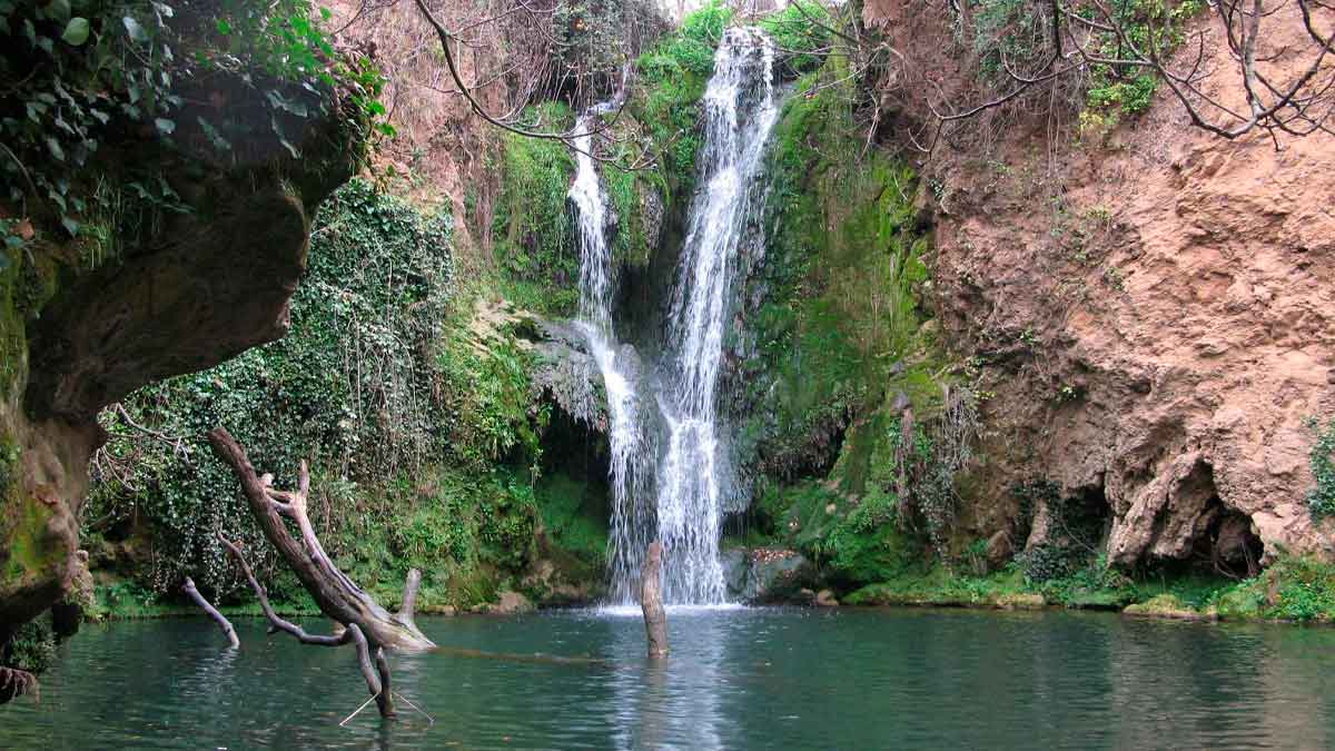 Cascada natural entre vegetación y pozas en la ruta de senderismo de San Nicolás del Puerto, en la Sierra Norte de Sevilla