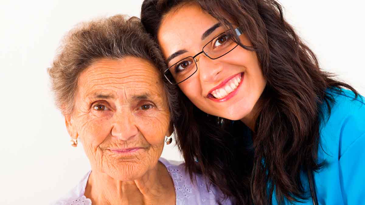 Cuidadora familiar sonriente junto a persona mayor dependiente, ilustración del convenio especial de cotización de la TGSS