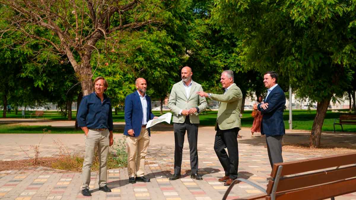 Responsables municipales recorren el nuevo parque de la Cruz del Campo en Sevilla, rodeados de árboles y senderos peatonales