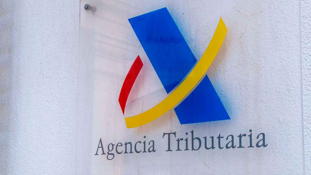 Logotipo de la Agencia Tributaria en una placa exterior, entidad que gestiona la devolución de Hacienda y revisa las declaraciones de la Renta