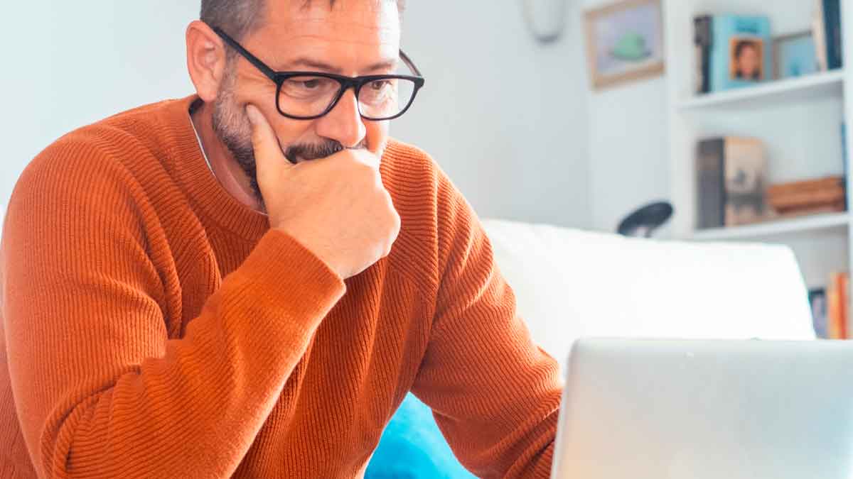 Hombre preocupado mirando su portátil por posible fraude de Seguridad Social