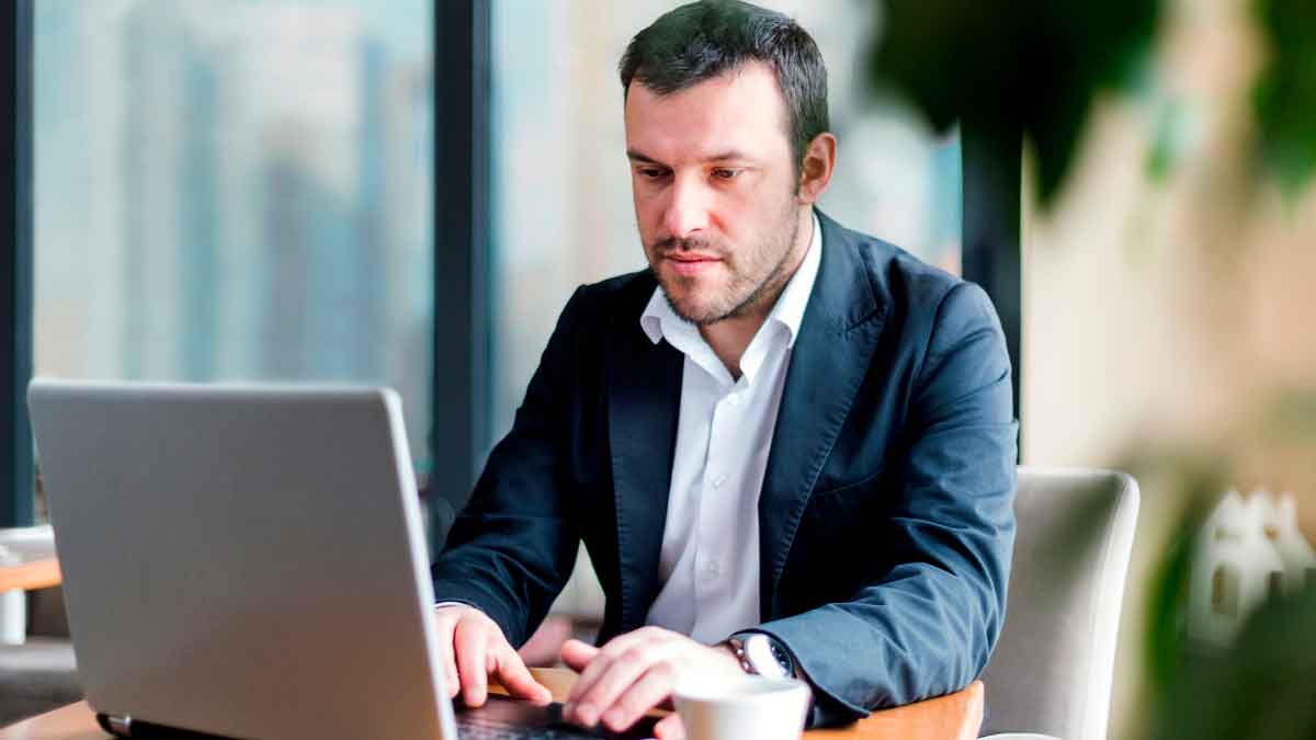 Autónomo trabajando en su ordenador portátil revisando nuevo sistema cotización