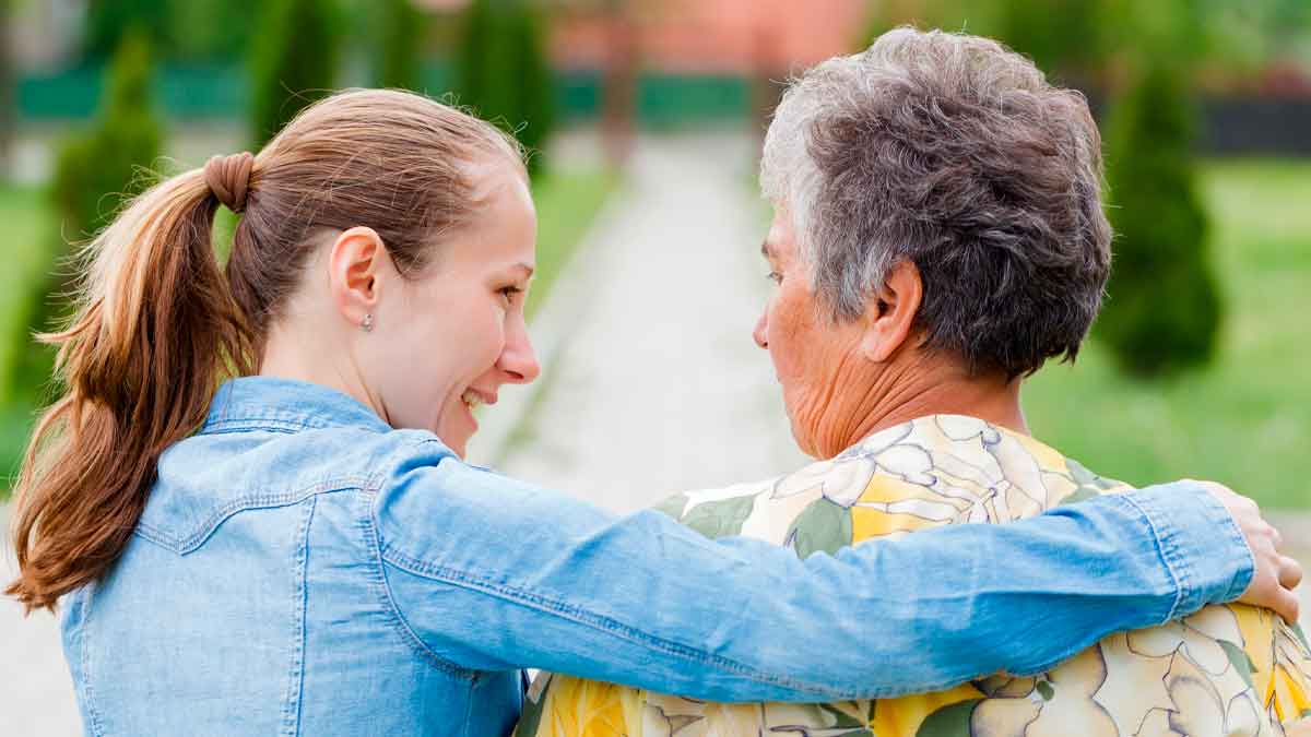 Joven abraza a una mujer mayor de 65 años, representación de la deducción de 1.150 € por convivir con ascendientes