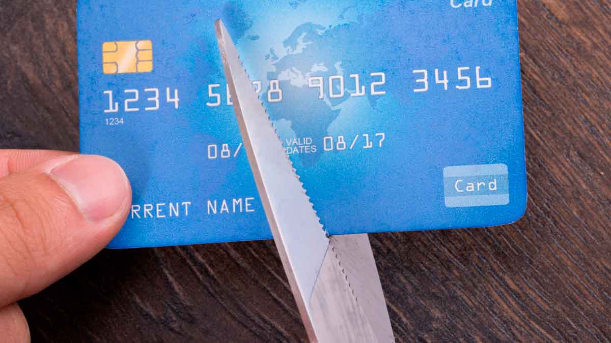 Tarjeta bancaria cortada con tijeras representando el bloqueo de cuentas y tarjetas por Hacienda a grandes contribuyentes morosos