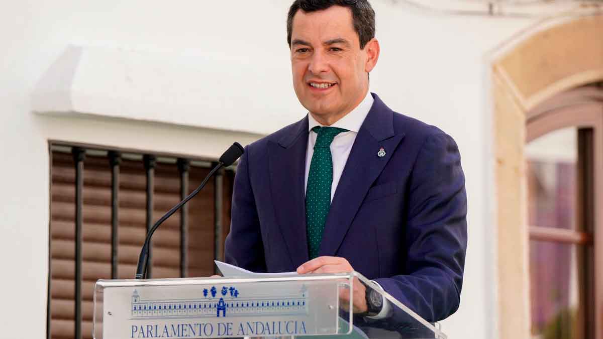 Juanma Moreno interviene en el atril del Parlamento de Andalucía al anunciar el decreto de ayudas a familias monoparentales.
