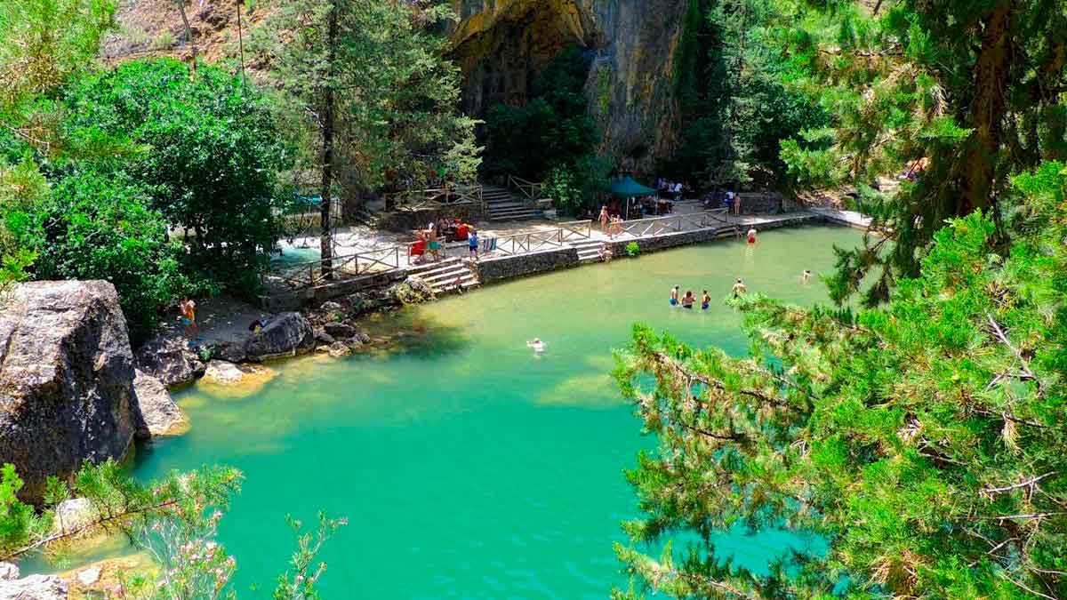 Piscina natural rodeada de vegetación, ideal para bañarse en Andalucía durante el verano