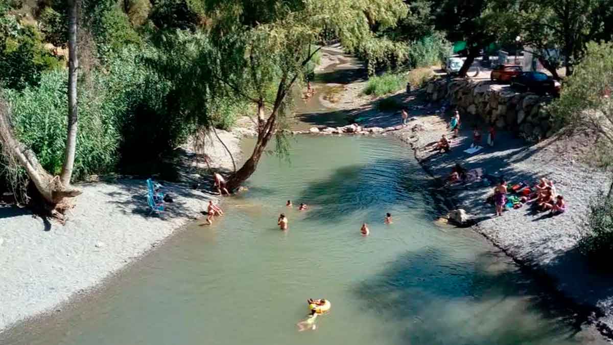 Familias bañándose en el Charco del Puente de San Juan, piscina natural del río Genal en la Serranía de Ronda, Málaga