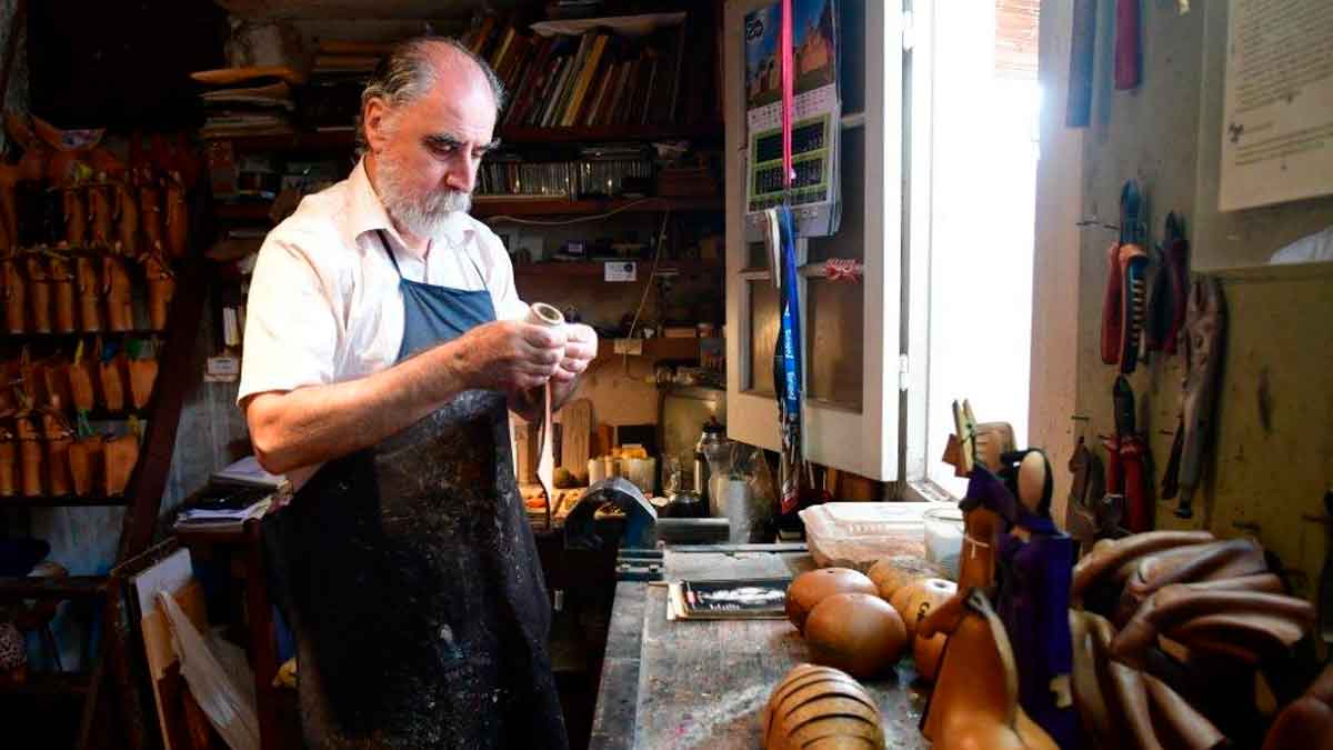 Artesano trabajando el cuero en su taller, industria tradicional del cuero en España, fabricación de productos de piel