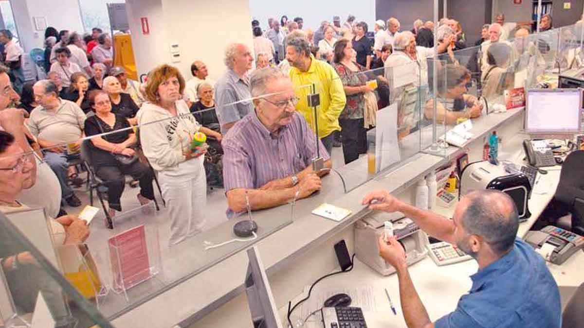 Clientes esperando en largas colas dentro de una sucursal bancaria, ilustrando problemas frecuentes reportados por usuarios según encuesta OCU