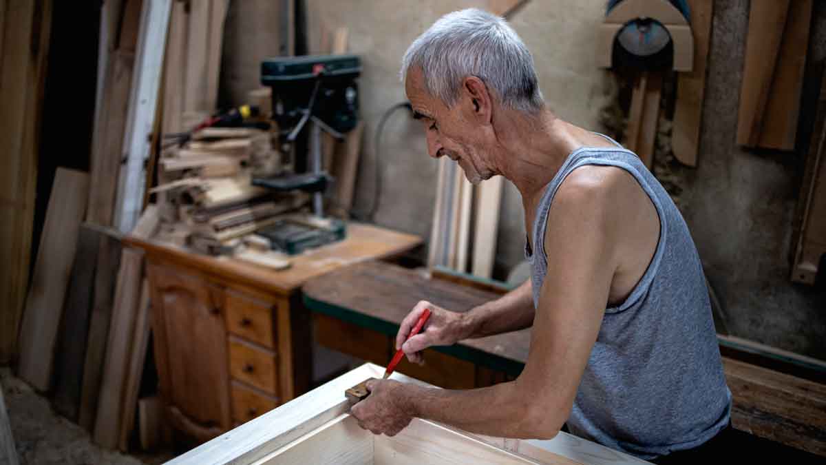 Hombre mayor en taller de carpintería que prolonga su vida laboral más allá de los 65 años para mejorar la pensión
