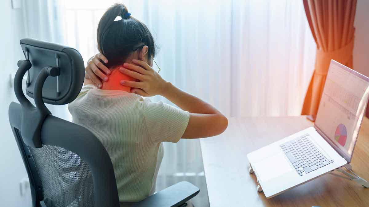 Mujer trabajadora con dolor cervical por fibromialgia frente al ordenador, candidata a incapacidad permanente absoluta de la Seguridad Social